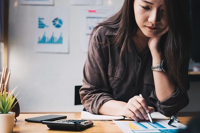 Business woman using calculator for do math finance on wooden desk in office and business working background, tax, accounting, statistics and analytic research concept, local movers